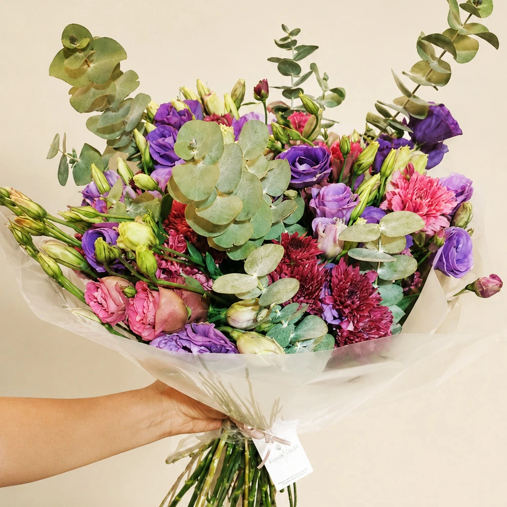 Bouquet de flores moradas, rosas y follaje de eucalipto